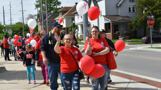 People with balloons wearing red AIDS Walk t-shirts
