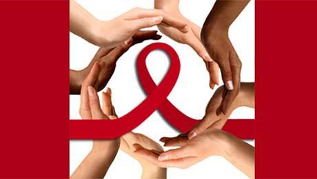 Hands surrounding a red AIDS ribbon in a circle