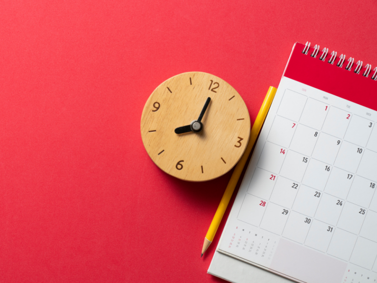 A small clock next to a partial calendar on a red background