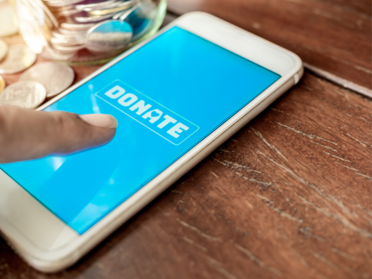 Person out of frame pushing a "donate" button on their phone