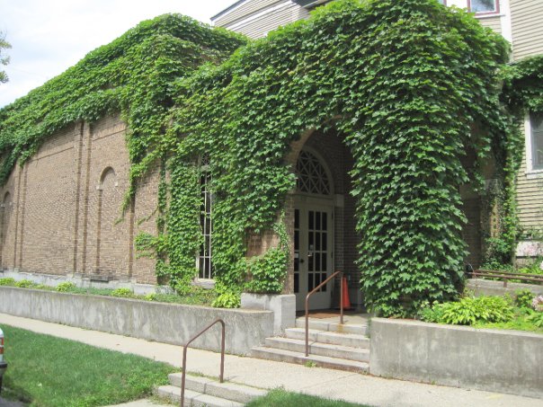 Outside view of Arena Dinner Theatre, quaint building entrance covered in vines and leaves.